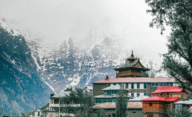 A Himachali village below snow-covered mountains